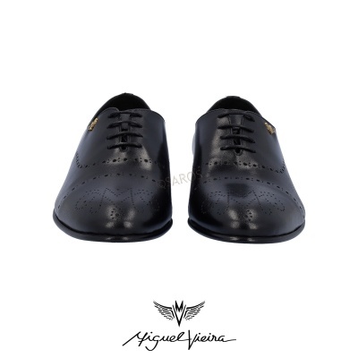 Sapatos clássicos pretos de couro com padrões perfurados e etiqueta dourada