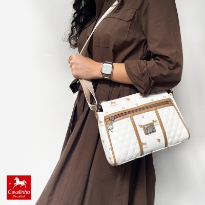 Mulher vestindo vestido castanho e mala branca Cavalinho Penafiel com padrões castanhos