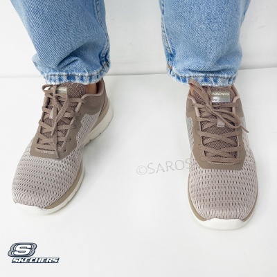 Sapatilhas Skechers bege e castanho usadas com jeans azuis claros