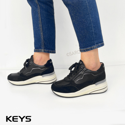 Ténis pretos de senhora KEYS com detalhes cinza e sola branca usados com jeans azuis