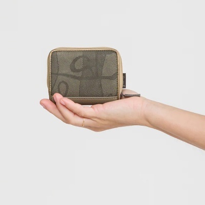 Carteira pequena cinzenta com padrão abstrato em mão sobre fundo cinza