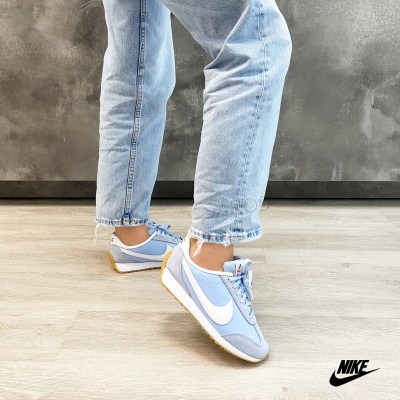 Ténis Nike azuis claros com sola castanha usados com jeans claros