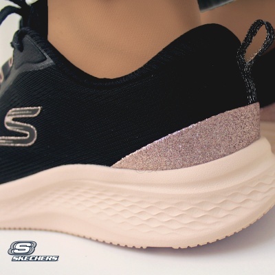Ténis Skechers pretos com sola beige e brilho rosa atrás