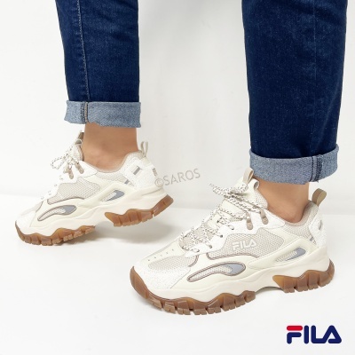 Ténis FILA creme com sola castanha usados com jeans azuis