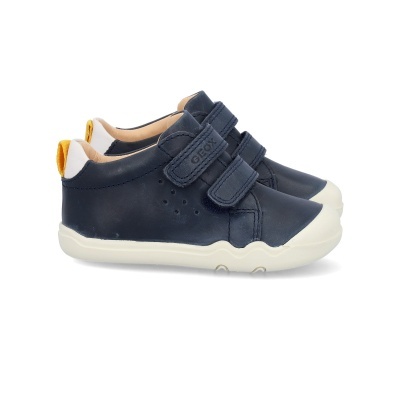 Sapatos de criança em couro azul escuro com sola branca e velcro.