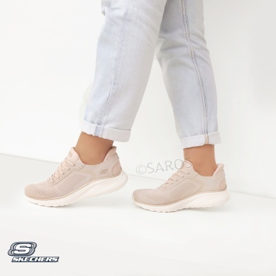 Ténis Skechers bege claro com sola branca em pessoa com calças de ganga claras.