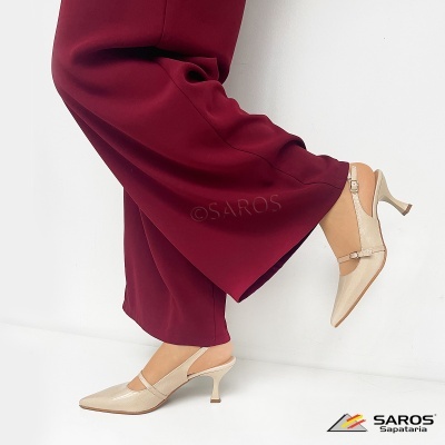 Sapatos de salto alto bege com calças vinho em fundo branco