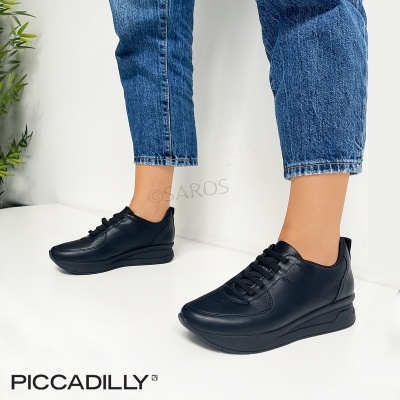 Ténis pretos casuais com sola elevada e jeans azuis