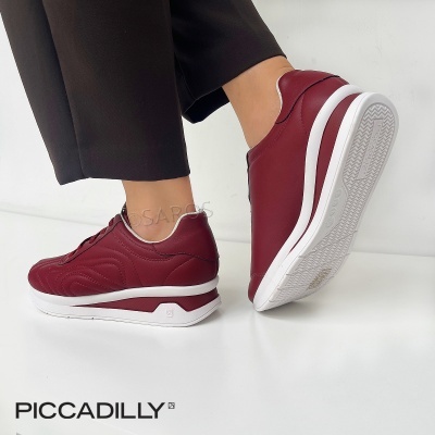 Sapatilhas vermelhas com sola branca da marca PICCADILLY, usadas com calças pretas.