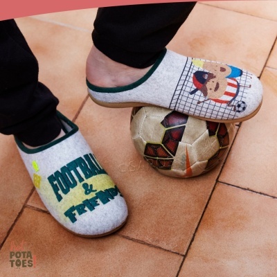 Chinelos cinza claro com texto e ilustração de cão a jogar futebol