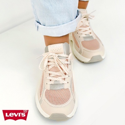 Ténis Levis rosa claro, bege e cinzento com atacadores, usados com ganga clara sobre fundo branco
