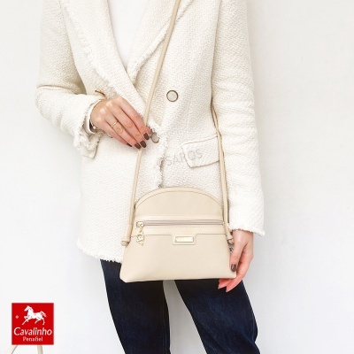 Pessoa com blazer bege texturizado e bolsa bege cruzada