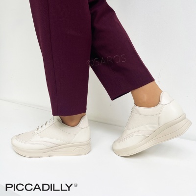 Ténis brancos PICCADILLY usados com calças roxas num fundo branco.