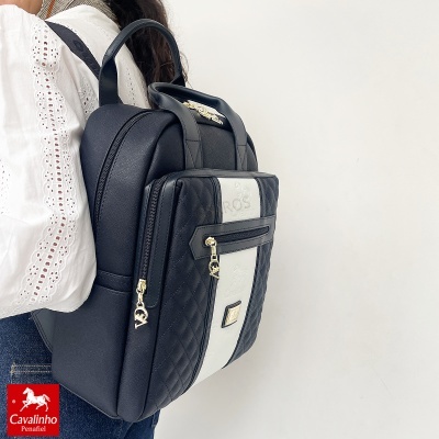 Mochila preta e branca acolchoada com fechos dourados e logo Cavalinho