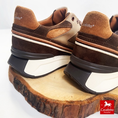 Ténis Cavalinho castanhos sobre base de madeira