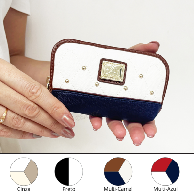 Carteira pequena branca, azul escuro e castanha com placa metálica e tachas douradas.