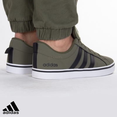 Ténis Adidas verdes com riscas pretas e sola branca