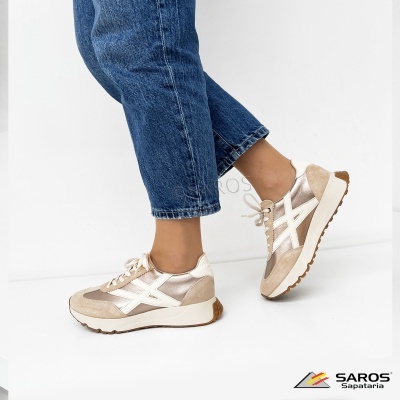 Ténis bege e bronze metalizado usados com calças de ganga azuis