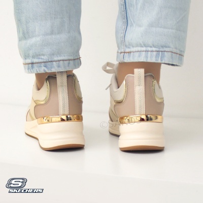 Ténis Skechers bege e dourado vistos de trás com jeans claros