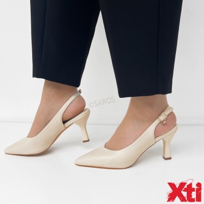 Sapatos bege de salto médio com tira e fivela dourada, usados com calças pretas