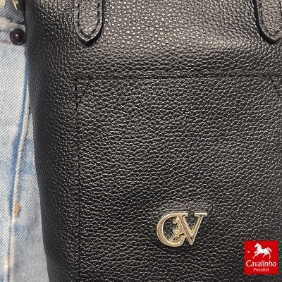 Mala preta em pele texturada com logótipo dourado CV e roupa de ganga azul claro