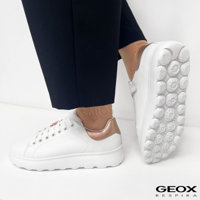 Ténis brancos em pele com detalhes metálicos dourados e sola branca com padrão circular