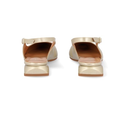Par de sapatos dourados com salto baixo e tira ajustável em fundo branco