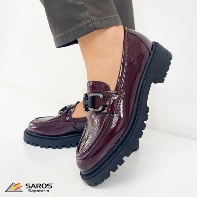 Sapatos tipo mocassim em verniz vinho com sola preta grossa e detalhe metálico