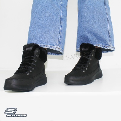 Botas pretas SKECHERS com pelo usadas com calças de ganga azul claro.