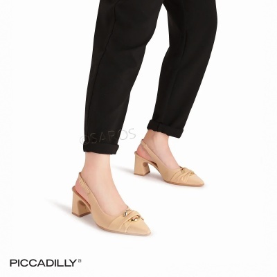 Sapatos de salto médio bege com detalhe dourado e calças pretas