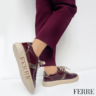 Ténis femininos bordeaux brilho com sola bege e logo FERRE, usados com calças bordeaux