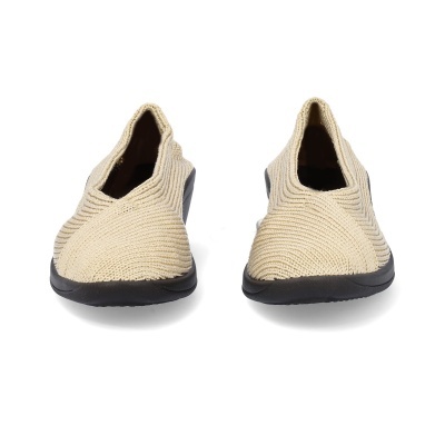 Sapatos tricotados bege com sola preta vistos de frente.