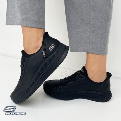 Ténis pretos Skechers usados com calças cinzentas