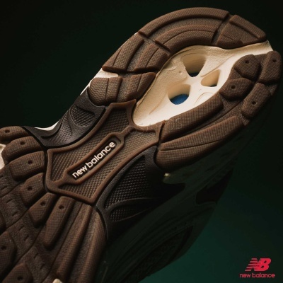 Sola de ténis New Balance em borracha castanha e bege com texto em relevo