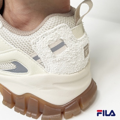 Ténis Fila bege com solado grosso castanho e detalhes em camurça e rede.