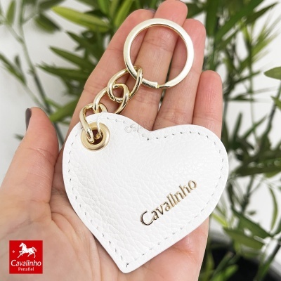 Chaveiro coração branco Cavalinho com corrente dourada na mão