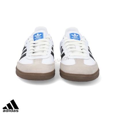 Ténis Adidas branco com riscas pretas e sola castanha vistos de frente