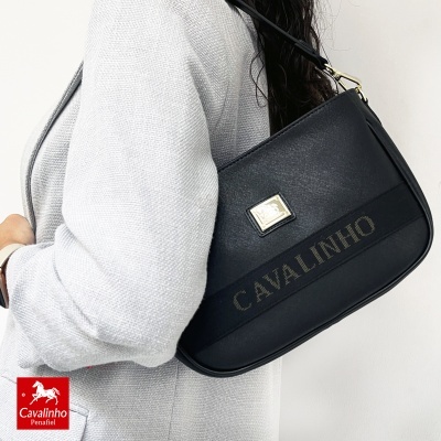 Mala preta Cavalinho com alça ao ombro sobre casaco cinzento