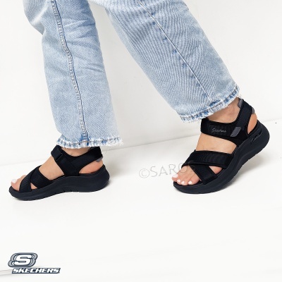 Sandálias pretas Skechers com tiras e sola grossa usadas com jeans claros