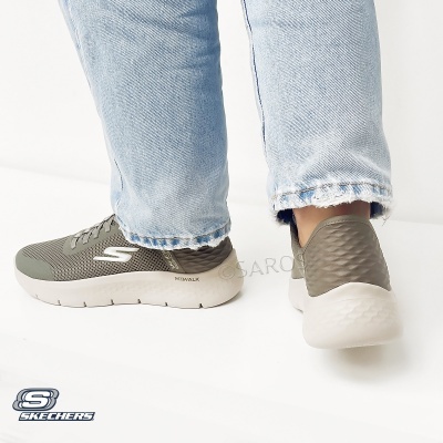 Ténis Skechers verdes cinza com sola branca usados com calças de ganga claras