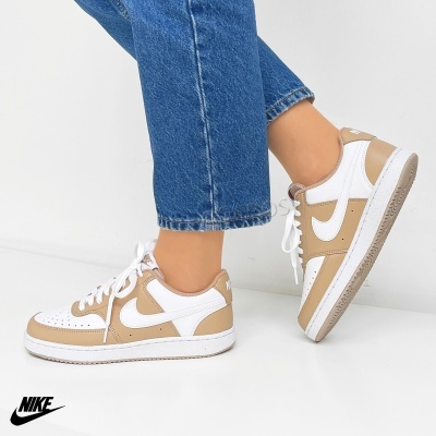 Ténis Nike em branco e bege usados com calças de ganga azul