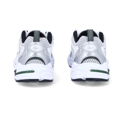 Vista traseira de ténis brancos com detalhes cinza e verde, sola branca e preta, padrão em malha e logótipo lacoste