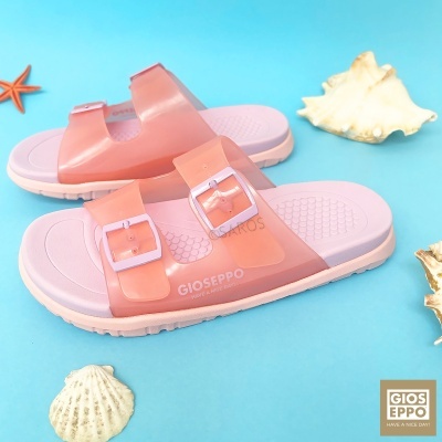 Chinelos rosa Gioseppo com duas tiras e fivelas sobre fundo azul e conchas