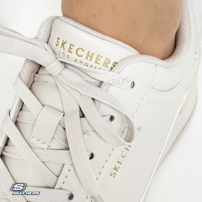 Ténis brancos Skechers com detalhes dourados e cadarços brancos