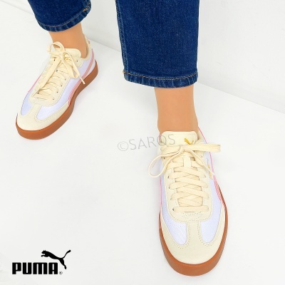 Sapatilhas PUMA bege e branco com sola castanha e logótipo amarelo, calçadas com calças de ganga azul