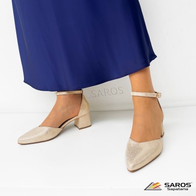 Sapatos femininos bege de salto médio com tira e fivela no tornozelo.