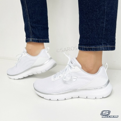 Ténis brancos Skechers com sola branca e atacadores, calças de ganga azuis
