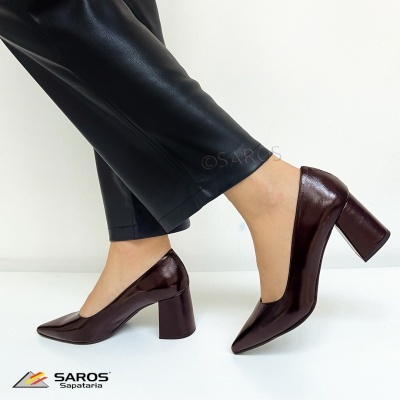 Sapatos de salto alto em pele castanha brilhante com calças pretas de pele