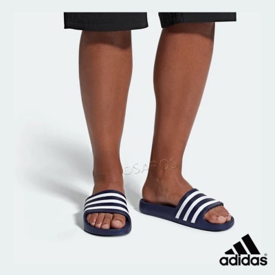 Chinelos Adidas azul escuro com riscas brancas usados em fundo claro