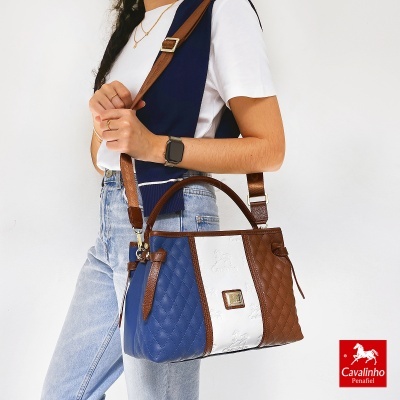 Mala de mão em azul, branco e castanho com padrão acolchoado e alça castanha ajustável